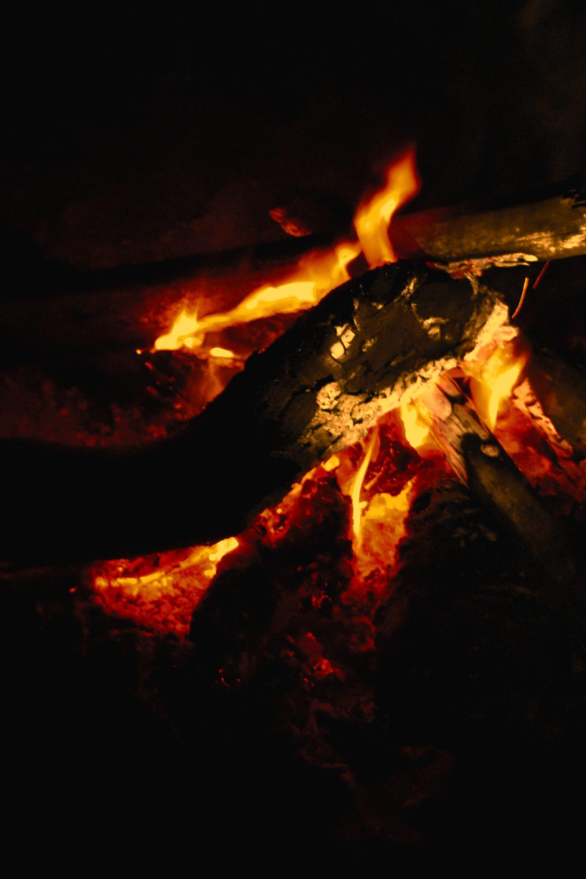 Embers and flames of a campfire in the dark