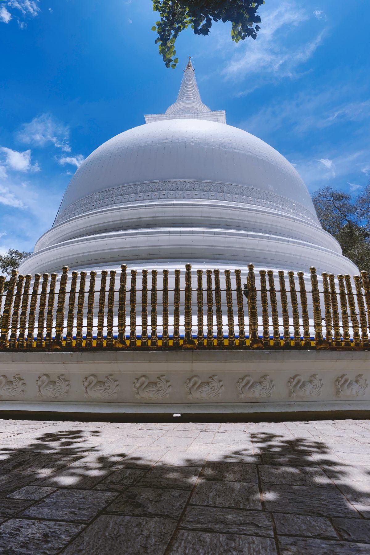 The white dome of Muthiyangana stupa against a blue sky